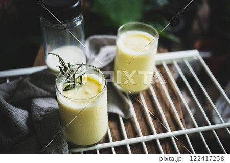 Corn juice smoothie on white rack placed on wood and plant backdrop in home garden pots.  top view 122417238