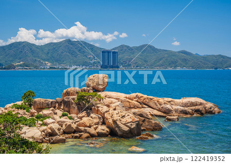 Large rocks on the background of the beach, mountains and high-rise buildings in Nha Trang. Hon Chong cape rock garden Large rocks on the background of the beach, mountains and high-rise buildings in Nha Trang. Hon Chong cape rock garden 122419352