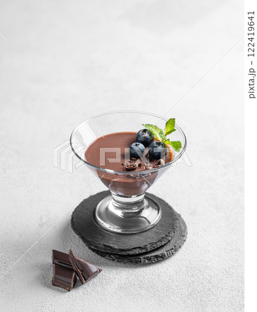 Chocolate pudding in a glass with fresh blueberries and mint on a light background Chocolate pudding in a glass with fresh blueberries and mint on a light background 122419641