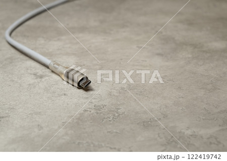 Micro USB charging cable on gray background. Charging cord for household electrical appliances 122419742