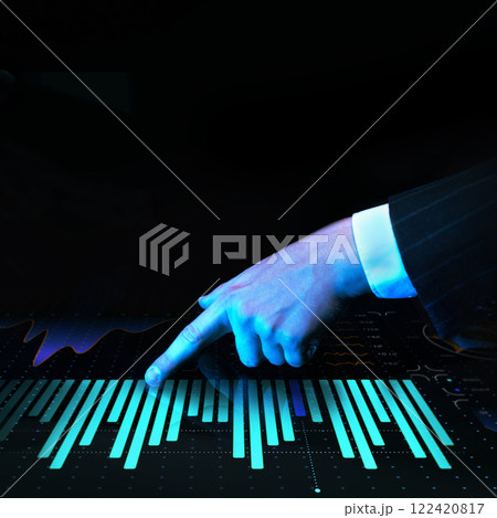Businessman pointing at illuminated bar graphs on futuristic digital interface featuring financial analytics, data visualization, and trends against dark background. 122420817