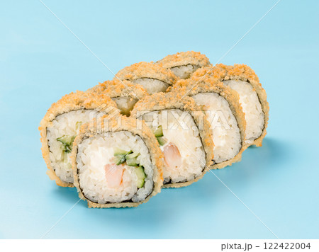 Studio photography of Hot Maki roll with cucumber and shrimp wrapped in nori. Isolated on solid light blue background. Sushi Perfection with Hot Maki Roll 122422004