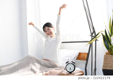 朝にベッドで起床する若いアジア人の女性 122422179