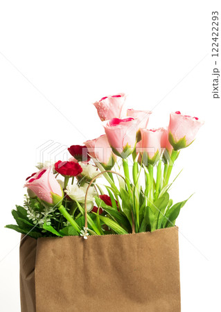 Beautiful bouquet of artificial flowers in a brown paper bag on a white background, copy space Beautiful bouquet of artificial flowers in a brown paper bag on a white background, copy space 122422293