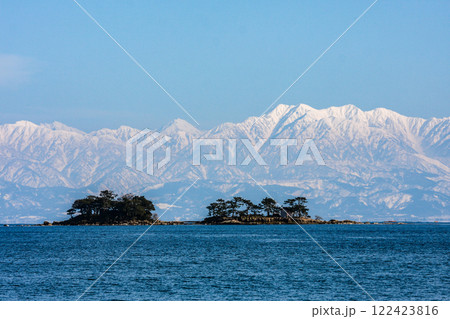 (とやまビューポイント)雨晴海岸より女岩と虻が島と冠雪の立山連峰　3月 122423816
