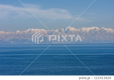 (とやまビューポイント)雨晴海岸より女岩と虻が島と冠雪の立山連峰　3月 122423820