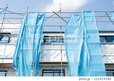 3軒の建売住宅を建設中で透湿防水シートを張り付けている様子 3軒の建売住宅を建設中で透湿防水シートを張り付けている様子 122424398