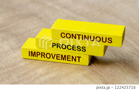 Continuous process improvement text on yellow wooden blocks. Business strategy and improvement concept 122425718