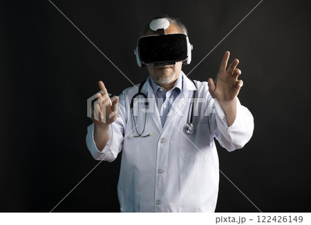 Telemedicine concept, old Asian doctor in lab uniform wearing VR glasses and operating medical task standing on black background. Telemedicine concept, old Asian doctor in lab uniform wearing VR glasses and operating medical task standing on black background. 122426149
