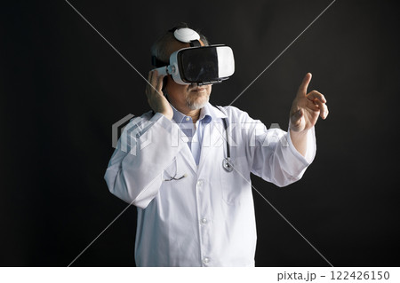 Telemedicine concept, old Asian doctor in lab uniform wearing VR glasses and operating medical task standing on black background. Telemedicine concept, old Asian doctor in lab uniform wearing VR glasses and operating medical task standing on black background. 122426150