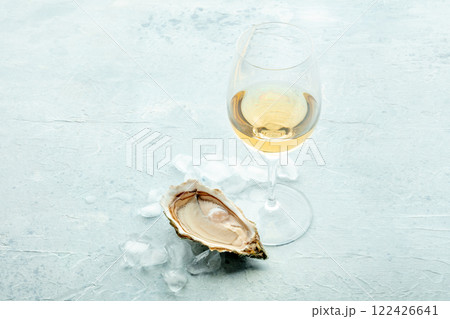 Oyster with a glass of wine, on ice, on a slate background 122426641