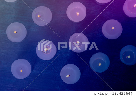 Tea light candles on a dark background, many lights in the dark Tea light candles on a dark background, many lights in the dark 122426644