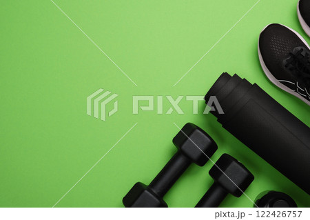 Black workout equipment for training at home on bright green background. Fitness, sport items, healthy lifestyle concept. Copyspace Black workout equipment for training at home on bright green background. Fitness, sport items, healthy lifestyle concept. Copyspace 122426757