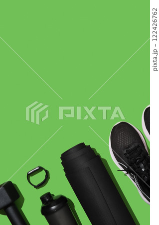 Black workout equipment for training at home on bright green background. Fitness, sport items, healthy lifestyle concept. Copyspace 122426762