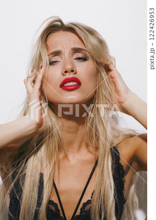 emotions and feelings concept - sensual blonde beauty in lingerie, moaning in orgasmic bliss, her glowing face illuminated by bright studio lighting as she fully surrenders emotions and feelings concept - sensual blonde beauty in lingerie, moaning in orgasmic bliss, her glowing face illuminated by bright studio lighting as she fully surrenders 122426953