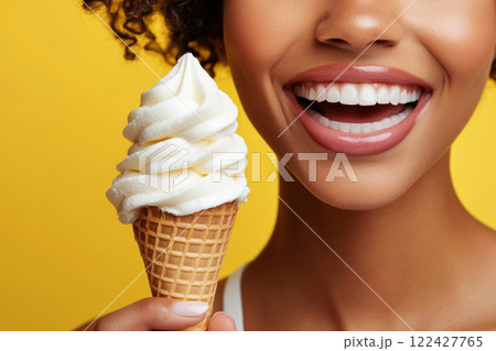 Smiling woman holding ice cream cone Smiling woman holding ice cream cone 122427765