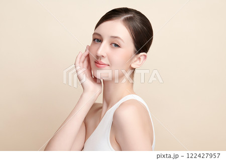 Beautiful young woman with clean fresh skin on beige background, Face care, Facial treatment, Cosmetology, beauty and spa, women portrait. 122427957
