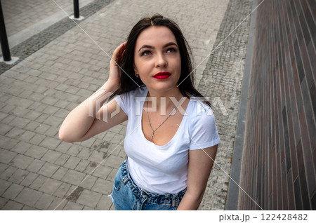 Young woman walking outdoors on a sunny day. Portrait of a cute woman outdoors. 122428482