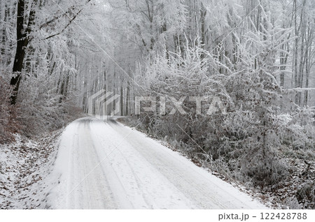 Snowy winter road with car. Dangerous car driving in the mountains in the winter. Concept for transportation, cars and travel. 122428788