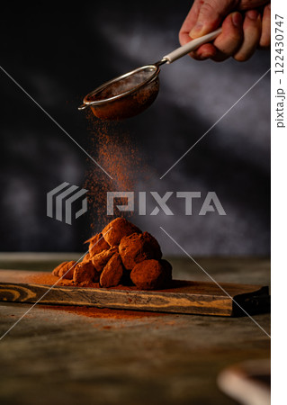 Tasty chocolate truffles powdered with cocoa on ta 122430747
