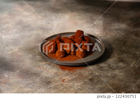 Tasty chocolate truffles powdered with cocoa on ta 122430751