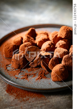 Tasty chocolate truffles powdered with cocoa on ta 122430758