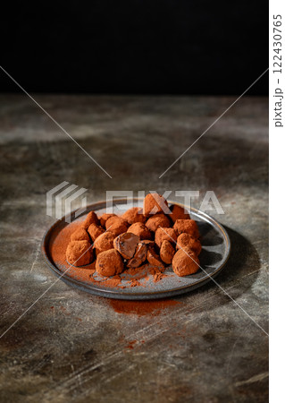 Tasty chocolate truffles powdered with cocoa on ta 122430765