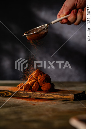 Tasty chocolate truffles powdered with cocoa on ta 122430774