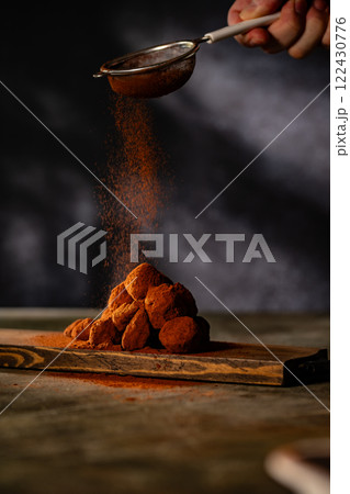 Tasty chocolate truffles powdered with cocoa on ta 122430776