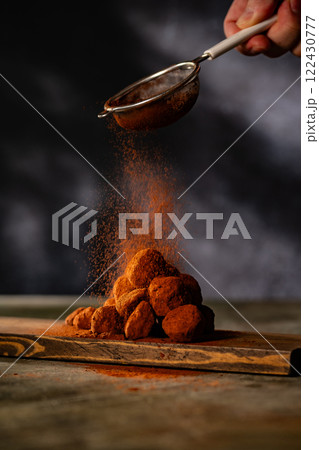 Tasty chocolate truffles powdered with cocoa on ta 122430777