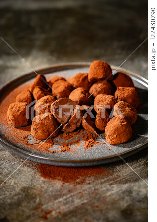 Tasty chocolate truffles powdered with cocoa on ta 122430790