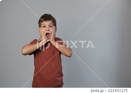 A child gasps, hands framing his face in surprise. Captures the candid, unfiltered reactions we value in the digital age. 122431175