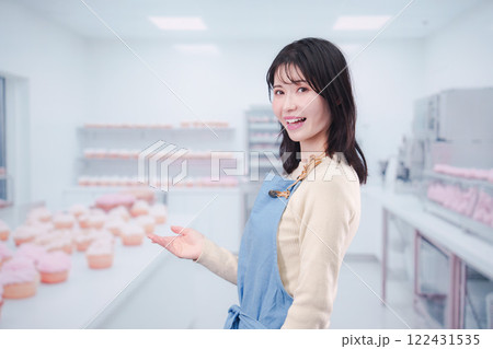 笑顔でお菓子作りをするパティシエの若い女性 笑顔でお菓子作りをするパティシエの若い女性 122431535