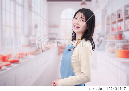 笑顔でお菓子作りをするパティシエの若い女性 笑顔でお菓子作りをするパティシエの若い女性 122431547