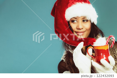 Winter girl santa helper hat holds red mug 122432093