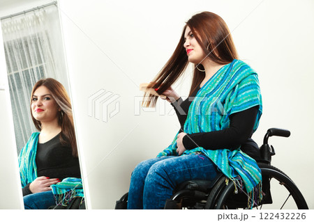 Invalid girl on wheelchair combing hair Invalid girl on wheelchair combing hair 122432226