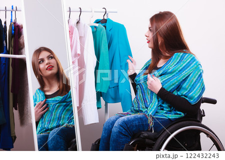 handicapped girl on wheelchair choosing clothes 122432243