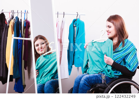 handicapped girl on wheelchair choosing clothes handicapped girl on wheelchair choosing clothes 122432249