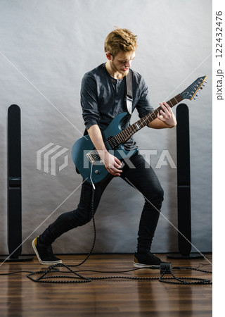 Young man playing electric guitar Young man playing electric guitar 122432476