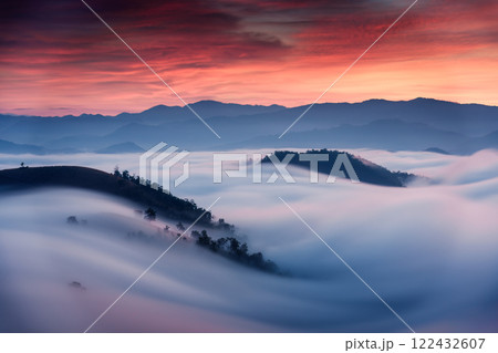Sea of fog flowing on hill in countryside at sunrise Sea of fog flowing on hill in countryside at sunrise 122432607