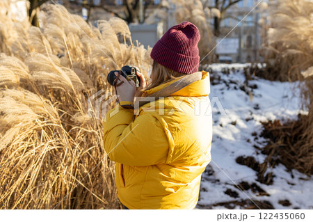 Professional woman photographer taking outdoor portraits with prime lens outdoors. Female taking pictures on vacation. Nature and sunlight. Professional woman photographer taking outdoor portraits with prime lens outdoors. Female taking pictures on vacation. Nature and sunlight. 122435060