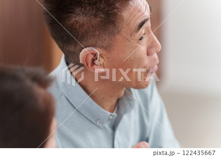補聴器をつけて会話するシニア男性 補聴器をつけて会話するシニア男性 122435667