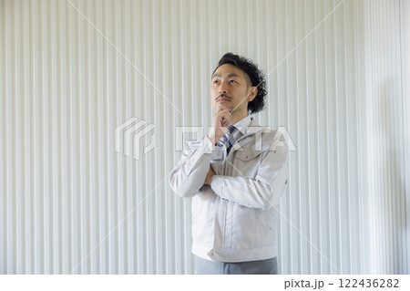 考える作業着を着たミドル男性 122436282