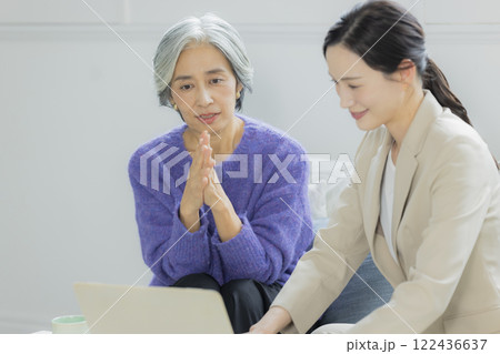 会話をするシニア女性とスーツの女性 122436637