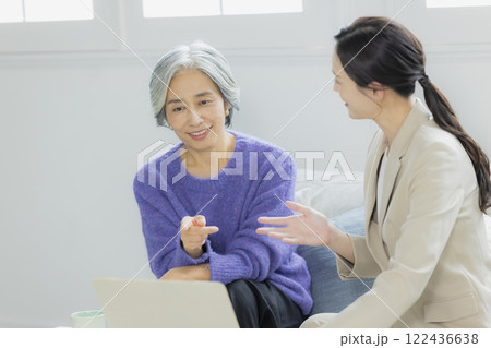 会話をするシニア女性とスーツの女性 122436638