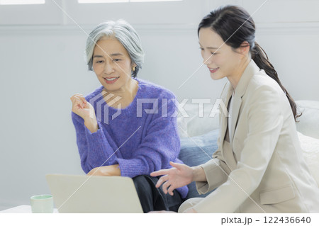 会話をするシニア女性とスーツの女性 会話をするシニア女性とスーツの女性 122436640