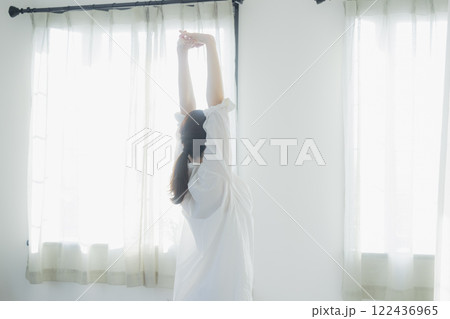 カーテンを開ける女性 122436965