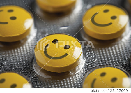A group of yellow pills with smiling faces on them. happy concept 122437069