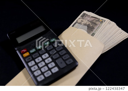 電卓と封筒に入っている旧紙幣の一万円札100枚 122438347
