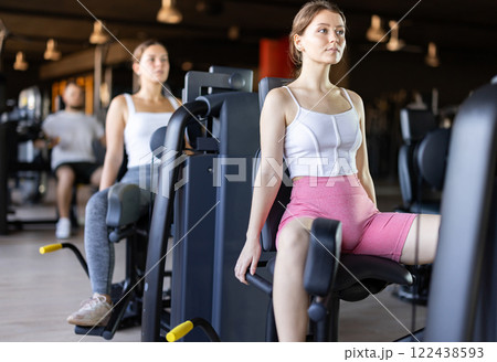 Young woman training her leg muscles on machine Young woman training her leg muscles on machine 122438593